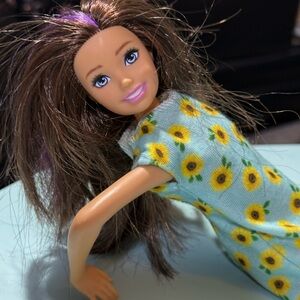 Barbie with brown hair and purple highlights in sun flower dress
